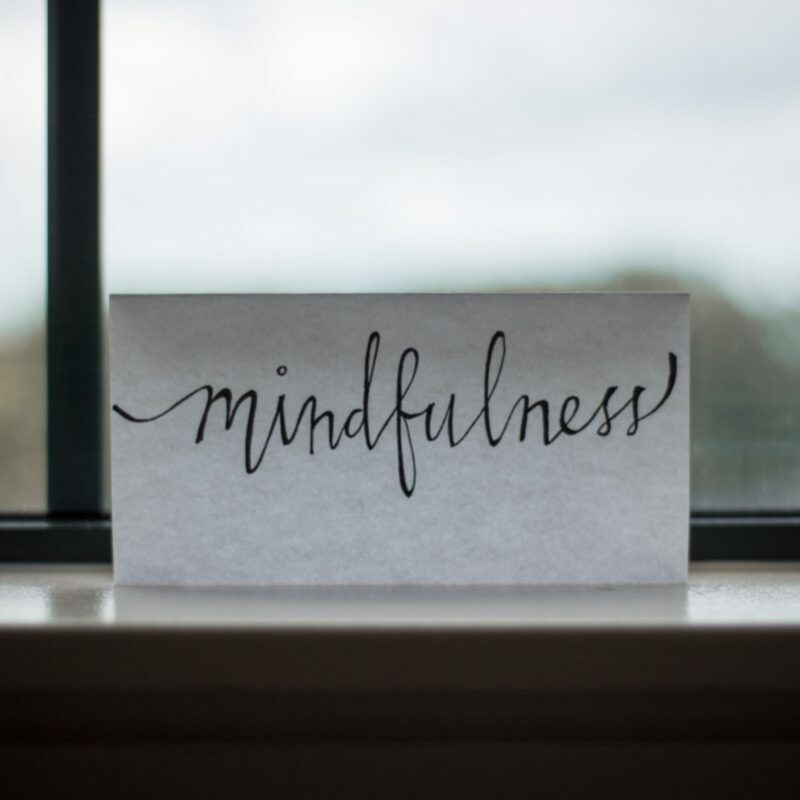 Carte posée sur un rebord de fenêtre avec le mot mindfulness écrit à la main